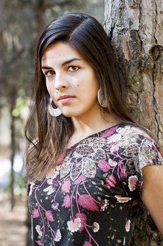 Beautiful girl with floral dress posing on a forest.