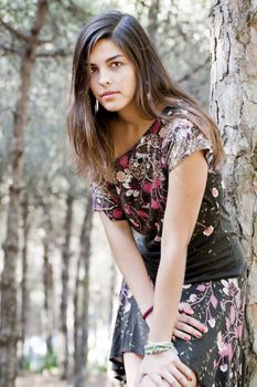Beautiful girl with floral dress posing on a forest.
