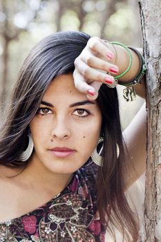 Beautiful girl with floral dress posing on a forest.