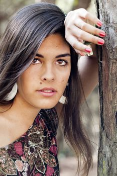Beautiful girl with floral dress posing on a forest.