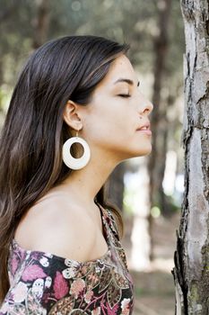 Beautiful girl with floral dress posing on a forest.