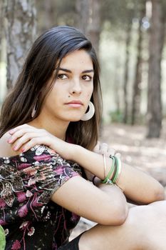 Beautiful girl with floral dress posing on a forest.