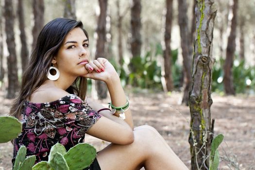 Beautiful girl with floral dress posing on a forest.