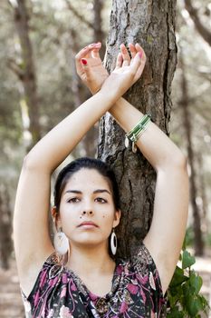 Beautiful girl with floral dress posing on a forest.