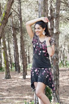 Beautiful girl with floral dress posing on a forest.