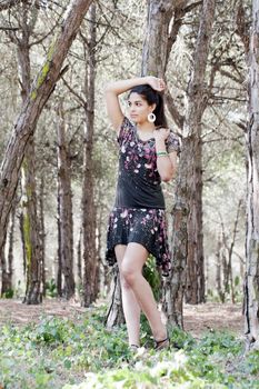 Beautiful girl with floral dress posing on a forest.