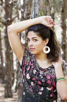 Beautiful girl with floral dress posing on a forest.