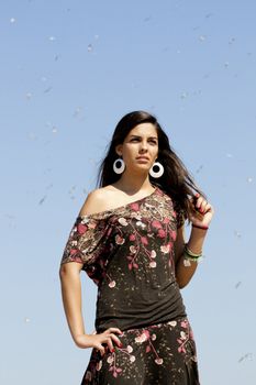Beautiful girl with floral dress posing on a forest with lots of birds.