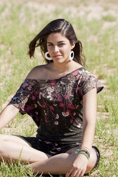 Beautiful girl with floral dress meditating on the nature.
