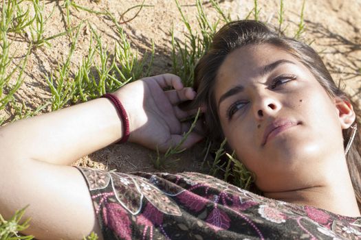 Beautiful girl with floral dress sleeping on the nature.
