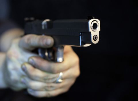 Man pointing a gun looking at the camera