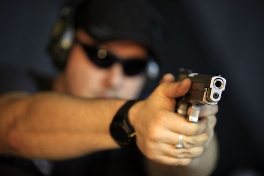 Man pointing a gun looking at the camera