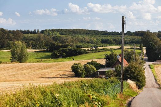 country landscape with farm buildings, fields, trees and hills