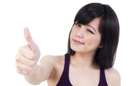 Portrait of an attractive young woman winking and giving thumb up gesture, isolated on white background.