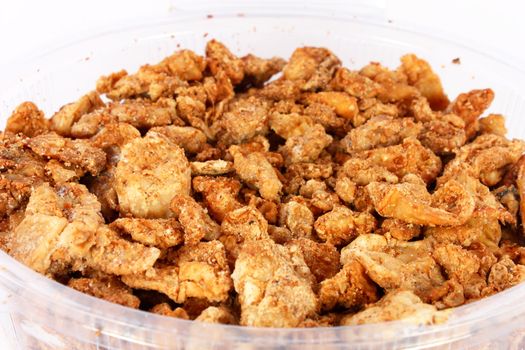Pork greaves in plastic bowl on white