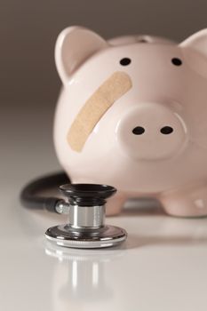 Piggy Bank and Stethoscope with Selective Focus on a Gradated Background.