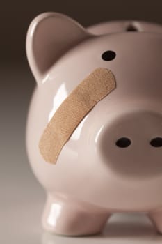 Piggy Bank with Bandage on Face on Gradated Background.