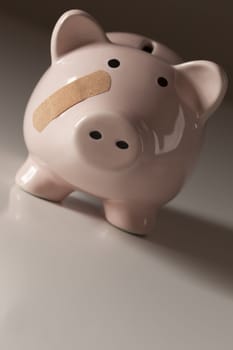 Piggy Bank with Bandage on Face on Gradated Background.