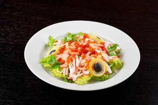 Salad with shrimps, caviar, calamaries, lettuce, lemon and olive