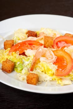 Salad of tiger shrimps, lettuce, chinese cabbage, tomato, garlic rusk, parmesan cheese and sauce