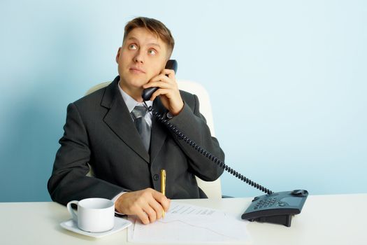 thoughtful young man with a telephone in the office
