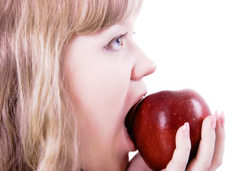 blonde girl bites the big red apple on a white background
