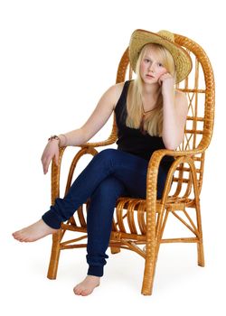 dreamy girl is sitting in a wicker chair. Isolated white background
