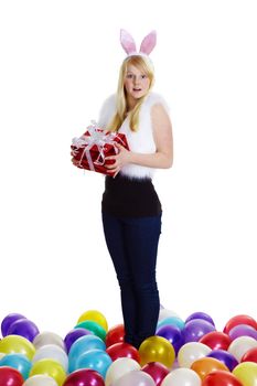 girl dressed as a rabbit with a gift in his hands and balloons on a white background
