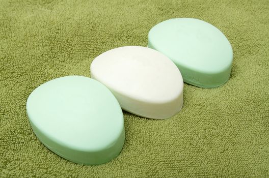 Three bars of soap on the green bath towel