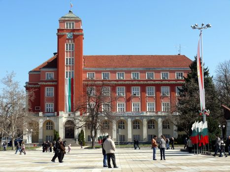 Pleven, Bulgaria - March 03, 2010: Spring day. Peoples walks near town hall in central square. Pleven, Bulgaria