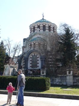 Pleven, Bulgaria - March 03, 2010: Spring day. Peoples walks near St George the Conqueror Chapel Mausoleum. Pleven, Bulgaria