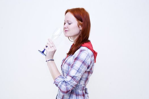 Redhead young woman is drinking from glass wine