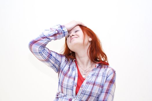 Redhead young woman holding her hand to the head with headache