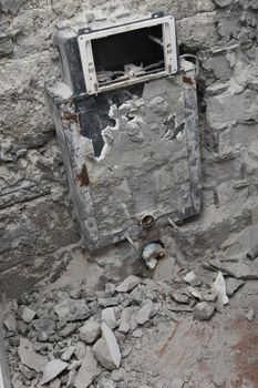 an un-plastered wall with building rubble in the bathroom
