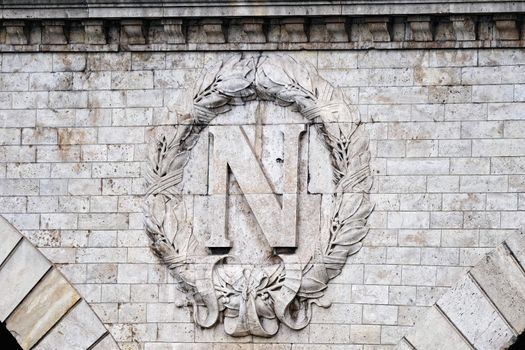 Insignia by Napoleon on the wall of Parisian bridge
