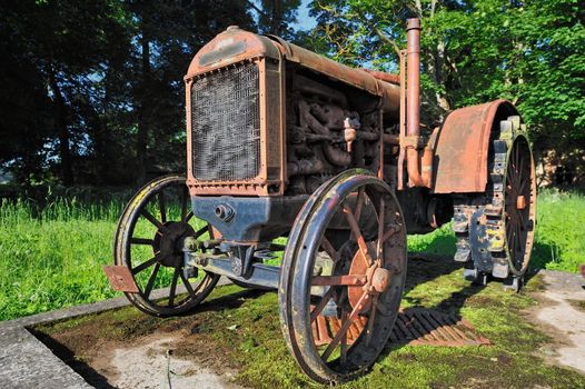 Old rusty small tractor in rural grove