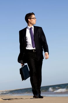 View of a bunisess man in a dark suit walking with briefcase.