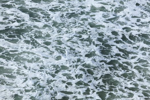 Aerial view of the foamy ocean surface just after a wave.