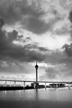Dramatic cityscape with clouds and towers and bridge in black and white in Macao, Asia.