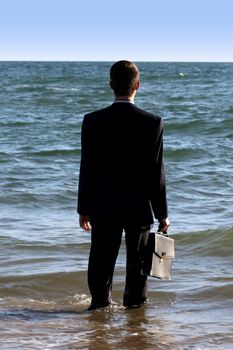 Business man watches the horizon of the sea.