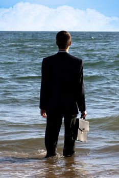 Business man watches the horizon of the sea.