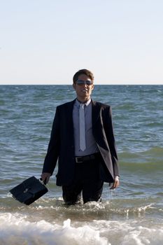 Brave business man in the shoreline of the beach.