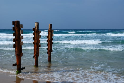 Old rusty pier piles on sea shore