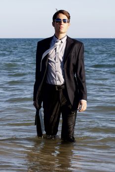 Brave business man in the shoreline of the beach.