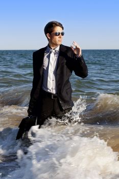 Brave business man in the shoreline of the beach.