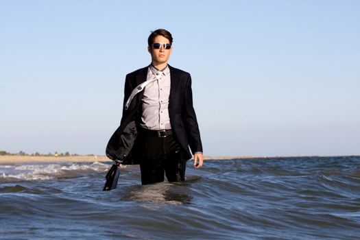Brave business man in the shoreline of the beach.