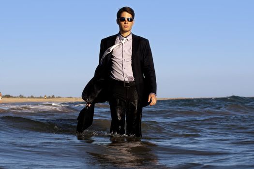 Brave business man in the shoreline of the beach.