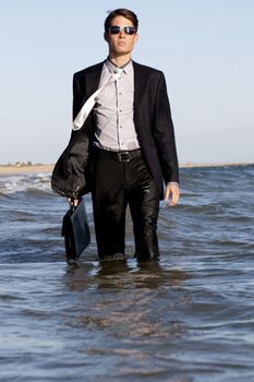 Brave business man in the shoreline of the beach.