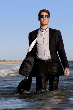 Brave business man in the shoreline of the beach.