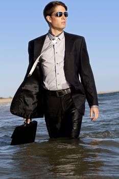 Brave business man in the shoreline of the beach.